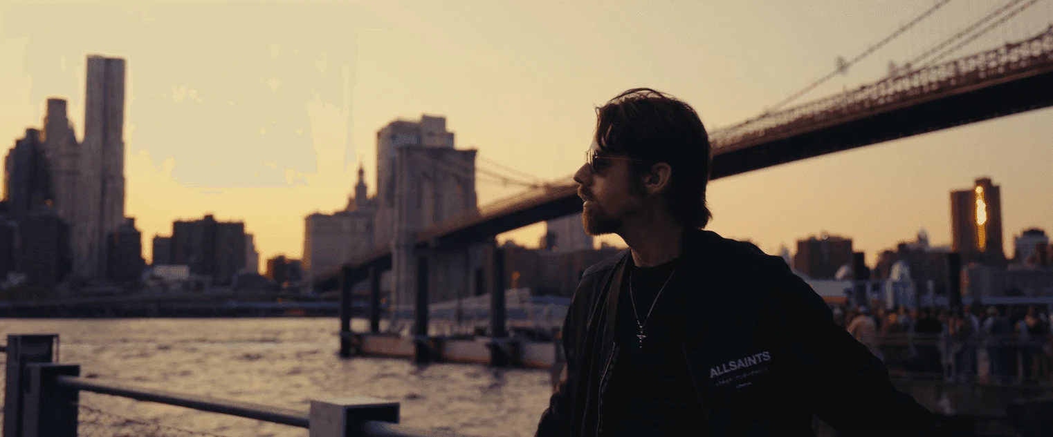 Reece Stone by the waterfront with the New York skyline behind him
